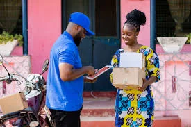 A courier handing a parcel to a customer at her front door