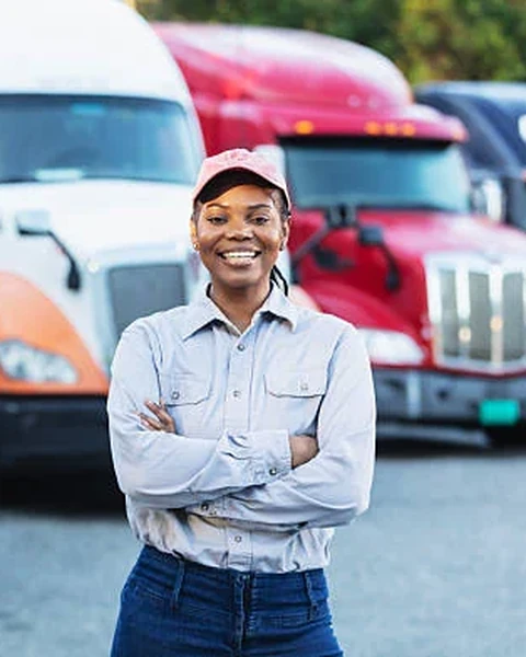 A fleet owner standing in front of her trucks